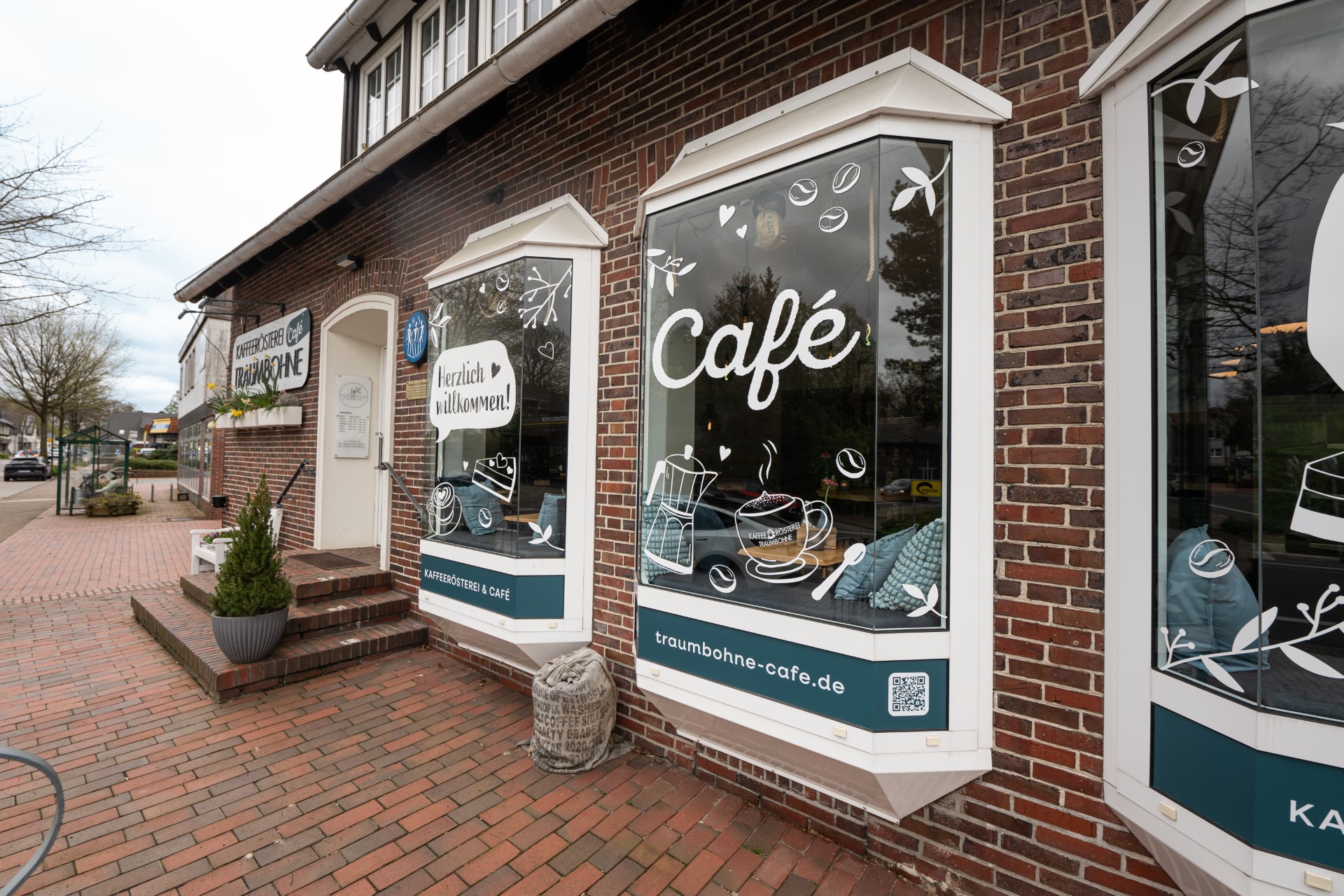Wunderschöne Außenfassade eines Cafégebäudes mit einladender Fensterbeschriftung