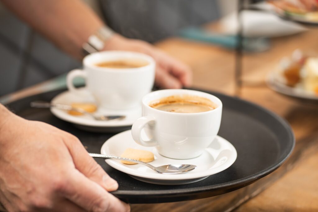 Zwei Tassen Cappuccino werden auf einem Tablett gebracht